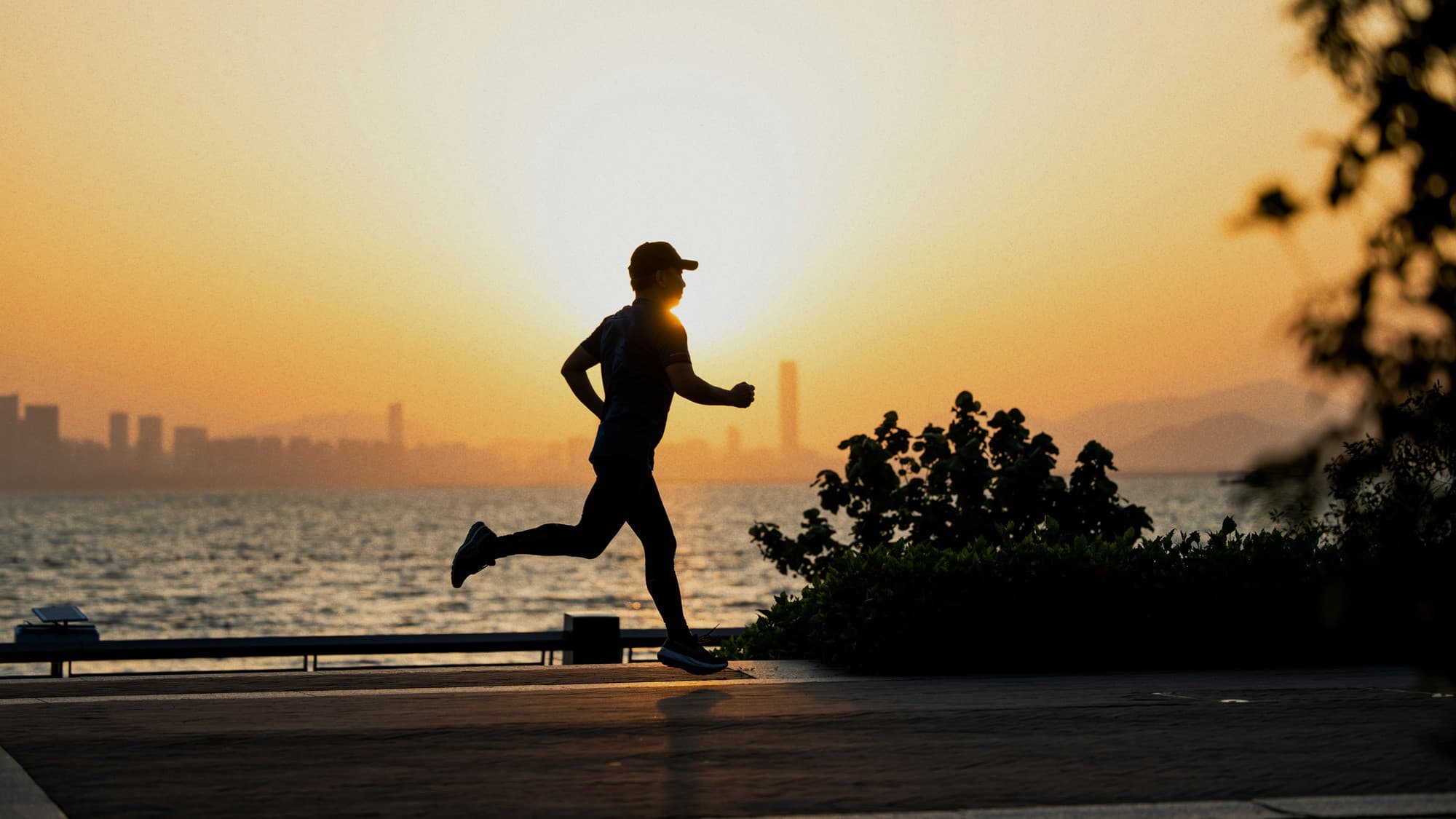 A person running at sunset along an open road.